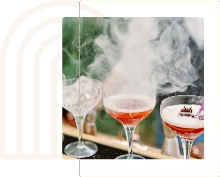 Présentation de verres à cocktails décorés avec du topping dont de la vapeur légérement blanche s'échappe d'un des verres