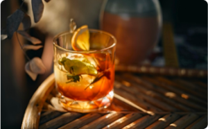 Mixologie : gros plan sur un verre à cocktail baigné de lumière posé sur une table.